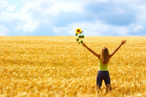 bigstock_Happy_young_woman_with_flower_13369865